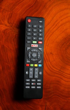 Foto de Control remoto de televisión con botones de Netflix y YouTube. Control para ver videos y películas en línea. Control remoto en mesa de madera. - Imagen libre de derechos