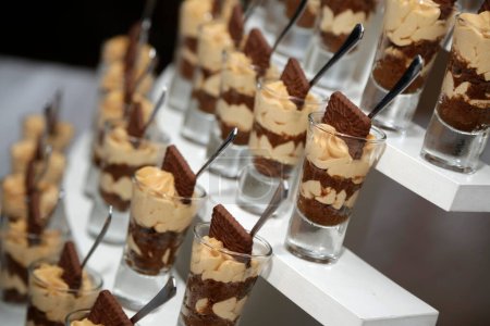 Süße Desserts aus Schokolade, Sahne und Keksen in einzelnen Gläsern. Nachtisch Gormet. Catering-Service für Feste und Veranstaltungen.