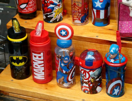 Foto de Gafas, cantimploras y botellas con los personajes de Batman, Spider-Man y Capitán América. Personajes de Marvel Studios. Merchandising productos para la venta en una tienda. Superhéroes. - Imagen libre de derechos