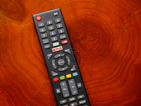 Foto de Control remoto de televisión con botones de Netflix y YouTube. Control para ver videos y películas en línea. Control remoto en mesa de madera. - Imagen libre de derechos