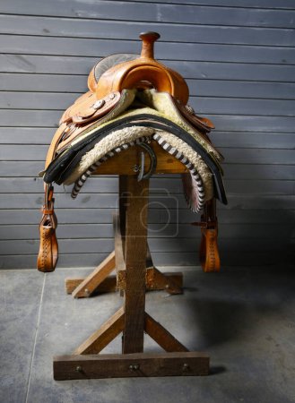 Horse mount. Horse saddle on wooden stand. Mounting accessory. Leather, metal and wool frame. Handmade. Craft. Argentina. horseback riding. Cowboy.