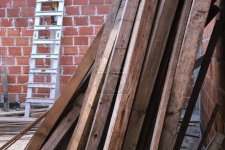 Vigas de madera apiladas en el sitio de construcción. Material de construcción. 