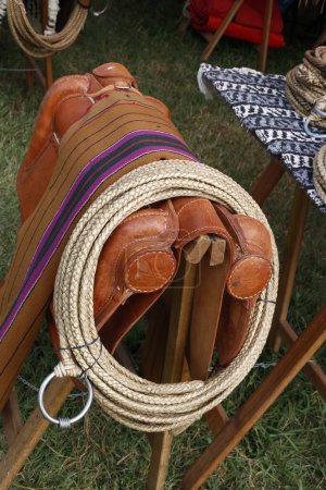 Photo for Horse saddle with harness and tack lasso for sale in an outdoor stall. Gaucho equipment. Horse implements. - Royalty Free Image