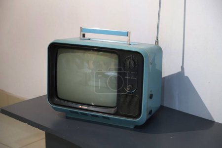 Téléchargez les photos : Vieux Hitachi télévision de marque des années 70 avec poignée transportable et antenne d'accord de canal. Télévision rétro bleu clair et noir. Télévision noir et blanc. - en image libre de droit