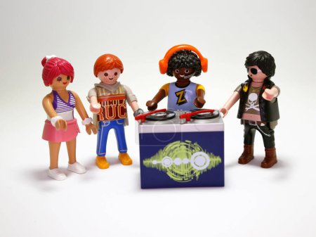 Photo for Playmobil dolls. DJ. Dis jockey. Disc jockey. DeeJay. Music. Musician. Toy for children. Collectible toy. Electronic party. Dance. Dancing people. Dream. Headphones. Vinyl disc. Isolated. - Royalty Free Image