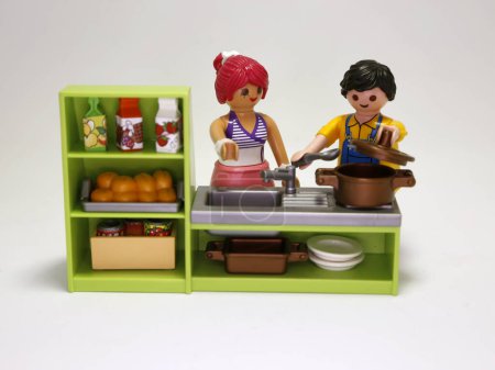 Foto de Playmobil dolls. Couple cooking. Man and woman making dinner. Family in their kitchen. Food preparation. Young couple. Toys for children. Isolated white. - Imagen libre de derechos