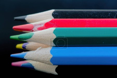 Téléchargez les photos : Vue rapprochée des pointes de crayons multicolores sur fond noir. Groupe de crayons de couleur. Peinture concept de passe-temps. - en image libre de droit