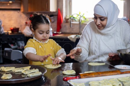 Enkelin hilft Großmutter bei der Herstellung von Gebäck in Küche, Mutter liebt Emotionen