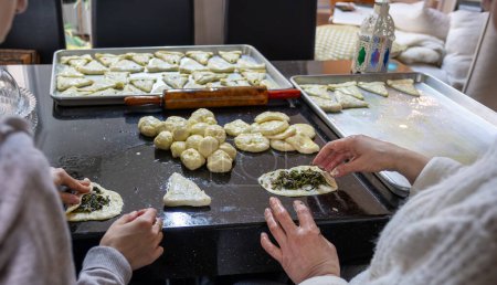 Photo for Mother and daughter are working together preparing pastries for dinner - Royalty Free Image