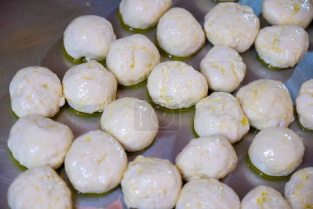 Teigbällchen auf Metallblech mit Olivenöl, damit sie nicht kleben und später geformt und gefüllt werden können