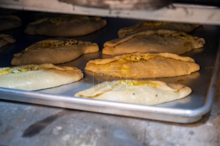 Photo for Pastries in oven being baked and freshly made of flour, olive oil and cheese, made according to jordan and palestine way - Royalty Free Image