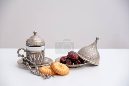 dates kahk eid sweets rosary and coffee cups on white isolated background