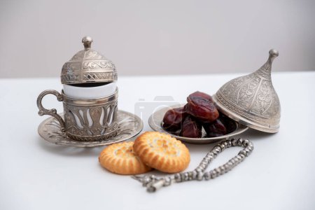 dates kahk eid sweets rosary and coffee cups on white isolated background