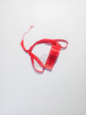 A small red whistle isolated on a white background.