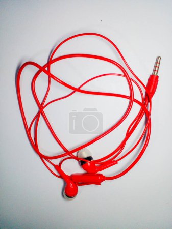 Foto de Auricular rojo aislado sobre fondo blanco. Auricular rojo para escuchar música. - Imagen libre de derechos