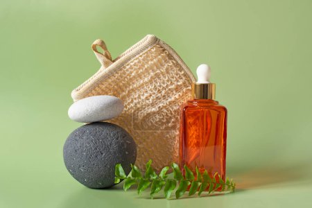 Photo for Pyramid of stones on a green background fern leaves, and a glass container for cosmetics. Spa concept, balance and tranquility - Royalty Free Image