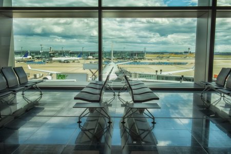 Foto de Sala de espera desierta en el aeropuerto con una vista de la zona con los aviones fuera de la ventana. - Imagen libre de derechos