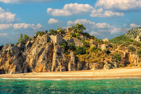 Foto de View of the beach and mountains with the remains of an antique fortress on the mountain slopes. Turkey. Kemer. Cirali. Mount Olympos, Tahtali. - Imagen libre de derechos