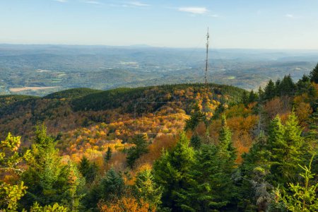 View of green mountains in autumn and a television broadcasting antenna tower. Vermont. USA
