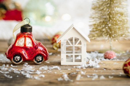 Photo for Christmas toy car, a small wooden house and details of Christmas decor on a blurred background. - Royalty Free Image