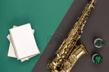 Foto de Fondo verde minimalista con saxofón y bloc de notas, vista superior, espacio para copiar. - Imagen libre de derechos