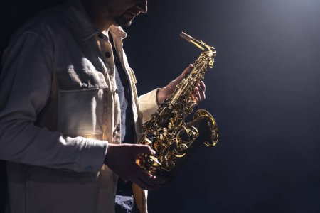 Foto de Músico masculino en el escenario toca el saxofón oscuro con humo, espacio para copiar. - Imagen libre de derechos