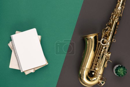 Foto de Fondo verde minimalista con saxofón y bloc de notas, vista superior, espacio para copiar. - Imagen libre de derechos