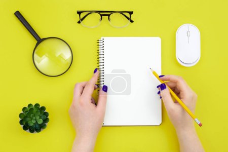 Photo for Blank notepad in female hands on a green background, flat lay, concept of hobies, work and creativity, copy space. - Royalty Free Image