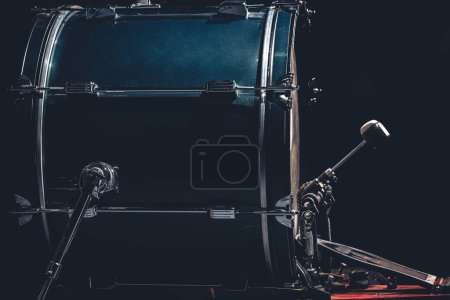 Tambour basse avec pédale, instrument de musique sur fond noir, espace de copie.