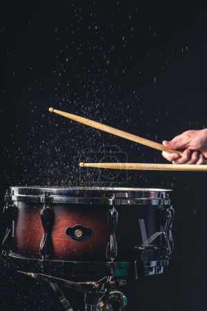 Photo for A male drummer plays the snare drum on a dark background, a musical percussion instrumentman. - Royalty Free Image