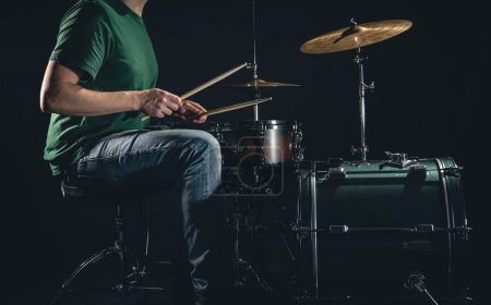 Photo for A male drummer plays a drum kit on a black background, a professional musician plays drums. - Royalty Free Image