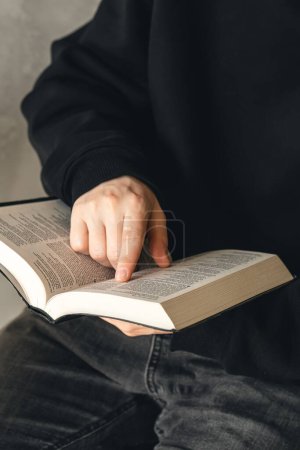 Téléchargez les photos : Ouvrir la Bible du livre saint entre les mains des hommes, gros plan, le concept de christianisme, la foi en Dieu. - en image libre de droit