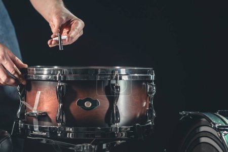 Photo for A male drummer plays the snare drum on a dark background, a musical percussion instrumentman, copy space. - Royalty Free Image