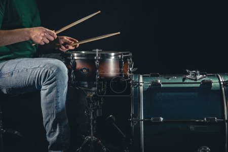 Photo for A male drummer plays a drum kit on a black background, a professional musician plays drums, copy space. - Royalty Free Image