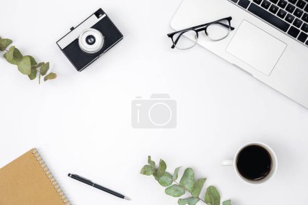 Foto de Flat lay fondo blanco con cámara retro, ordenador portátil, portátil, taza de café y vasos, vista superior, espacio para copiar. - Imagen libre de derechos
