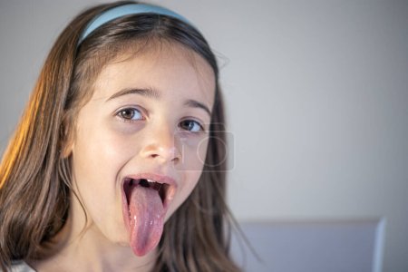 Téléchargez les photos : Une enfant fille ouvre la bouche et montre son salon, le concept de dentisterie, orthodontie. - en image libre de droit
