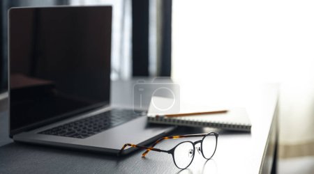 Photo for Laptop, glasses and notebok on the desktop on a blurred background, copy space. - Royalty Free Image