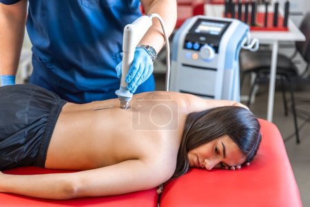 Photo for Extracorporeal shockwave therapy, physical therapy for neck and back muscles, spine with shock waves, pain relief, normalization and regeneration,stimulation healing process. - Royalty Free Image