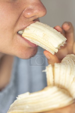 Téléchargez les photos : Plan détaillé d'une femme mange de la banane fraîche, plan macro. - en image libre de droit