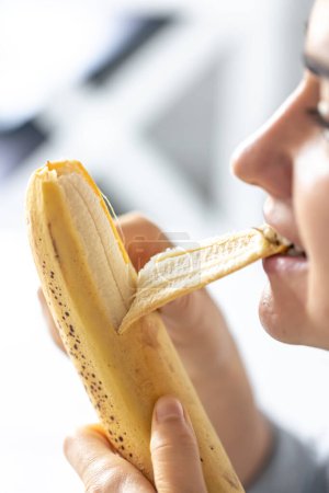 Téléchargez les photos : Plan détaillé d'une femme mange de la banane fraîche, plan macro. - en image libre de droit