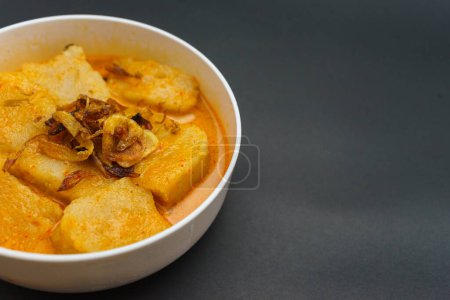 Laksan is a typical Palembang traditional food made from sago and fish. Laksan is made in an oval shape with served using coconut milk sauce. Isolated on black background.