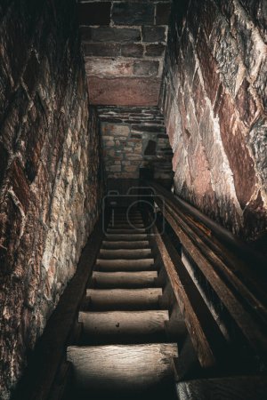 A dimly lit, narrow stone passage evokes tales of hidden secrets.
