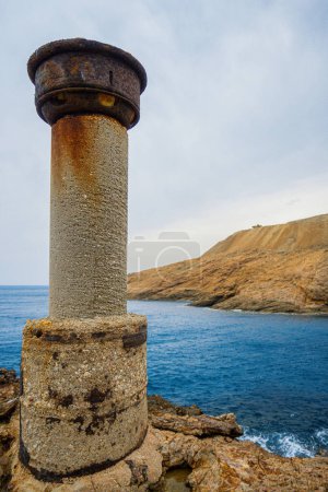 Téléchargez les photos : Une structure cylindrique corrodée est isolée, une sentinelle au bord de la mer. - en image libre de droit