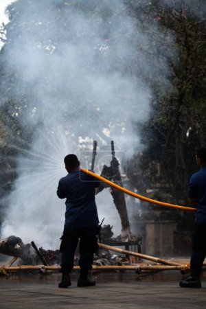 Photo for Jakarta, Indonesia. April 21, 2024. Firefighters spray extinguishing fire that burned Ogoh-ogoh at TMII tourist attraction, Jakarta - Royalty Free Image