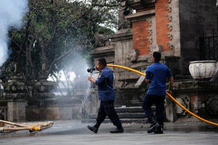 Photo for Jakarta, Indonesia. April 21, 2024. TMII, Jakarta: Firefighters extinguish flames on a burned Ogoh-ogoh - Royalty Free Image