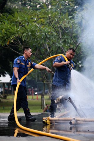 Foto de Yakarta, Indonesia. 21 de abril de 2024. Equipo de bomberos rocía agua en un Ogoh-ogoh ardiente en TMII, Yakarta - Imagen libre de derechos
