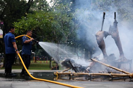 Téléchargez les photos : Jakarta, Indonésie. 21 avril 2024. Une équipe de pompiers pulvérise de l'eau sur un Ogoh-ogoh flamboyant à TMII, Jakarta - en image libre de droit