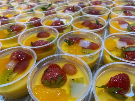 Catering - Home Industry - Production of healthy mango milk pudding. Puddings are made from mango juice and milk. Topping: vanilla jelly, strawberry, grape, kiwi, mandarin orange, and nata de coco (coconut gel)