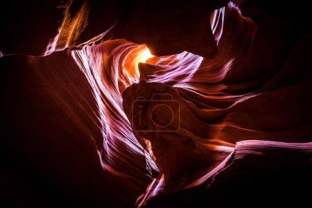 La luz del sol brilla a través de las rocas, creando un efecto visual llamativo en el cañón.