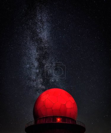 Una cúpula roja se alza prominentemente sobre un telón de fondo de un vibrante cielo lleno de estrellas.